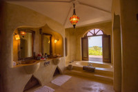 Matemwe Retreat - Main bathroom with double vanity, a large bath tub and views