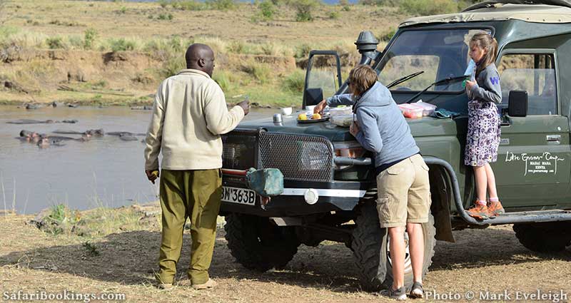 African Safari Guide making snack stop near Hippos