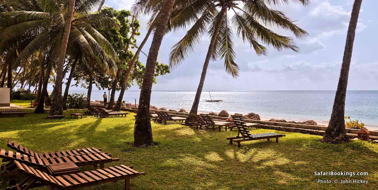 Sun loungers, shaded by palm trees, Bamburi Beach