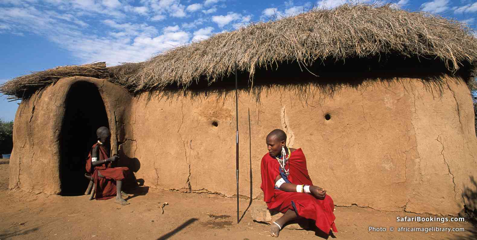 Maasai women in front of a traditional homestead