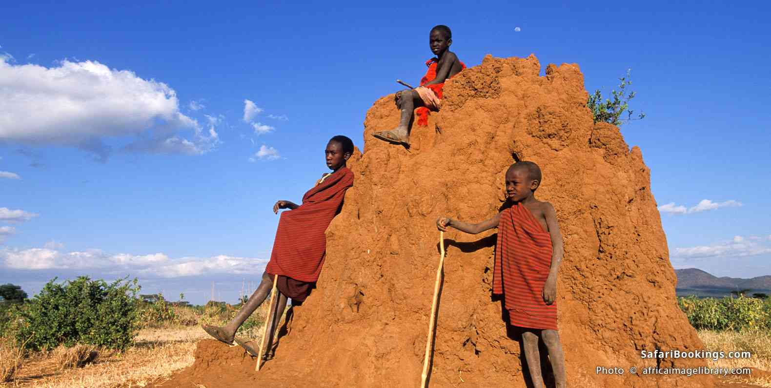 Maasai boys sitting on a termite mound