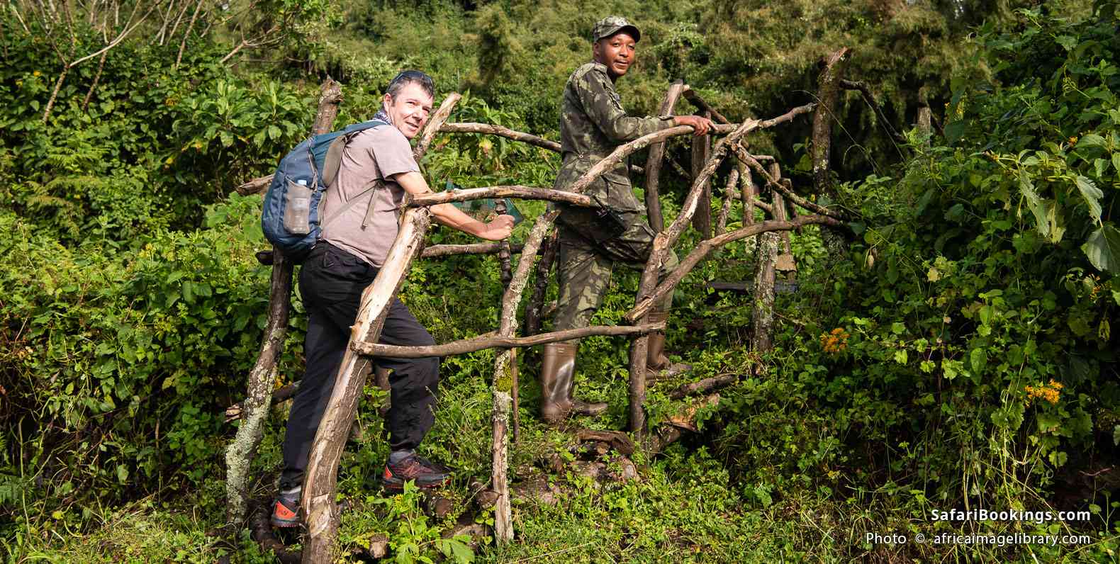 Guide and traveler entering Volcanoes National Park for gorilla trekking