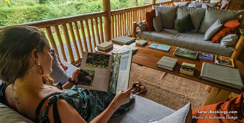 Woman reading a book about gorillas in the common area of Buhoma Lodge
