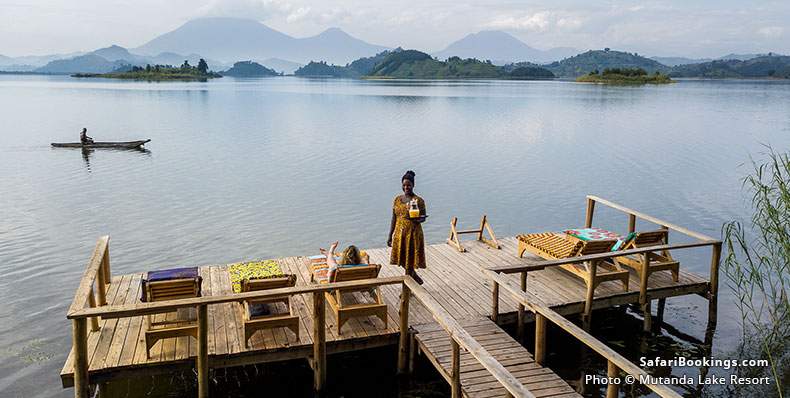 Women on the dock at Mutanda Lake Resort, with mountains in the background