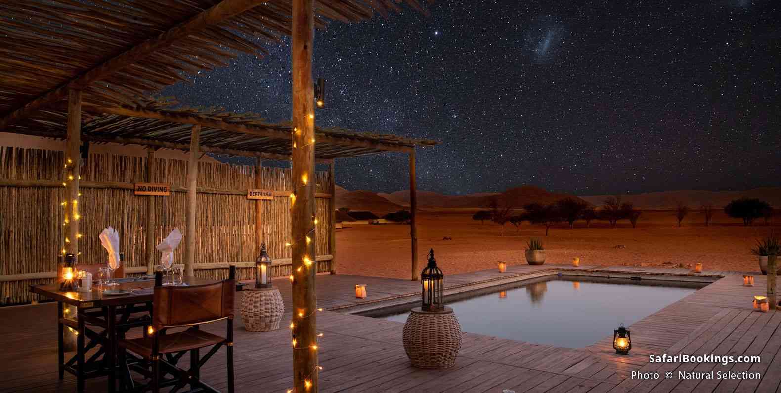 Pool area at Kwessi Dunes at night, with starry sky in the background