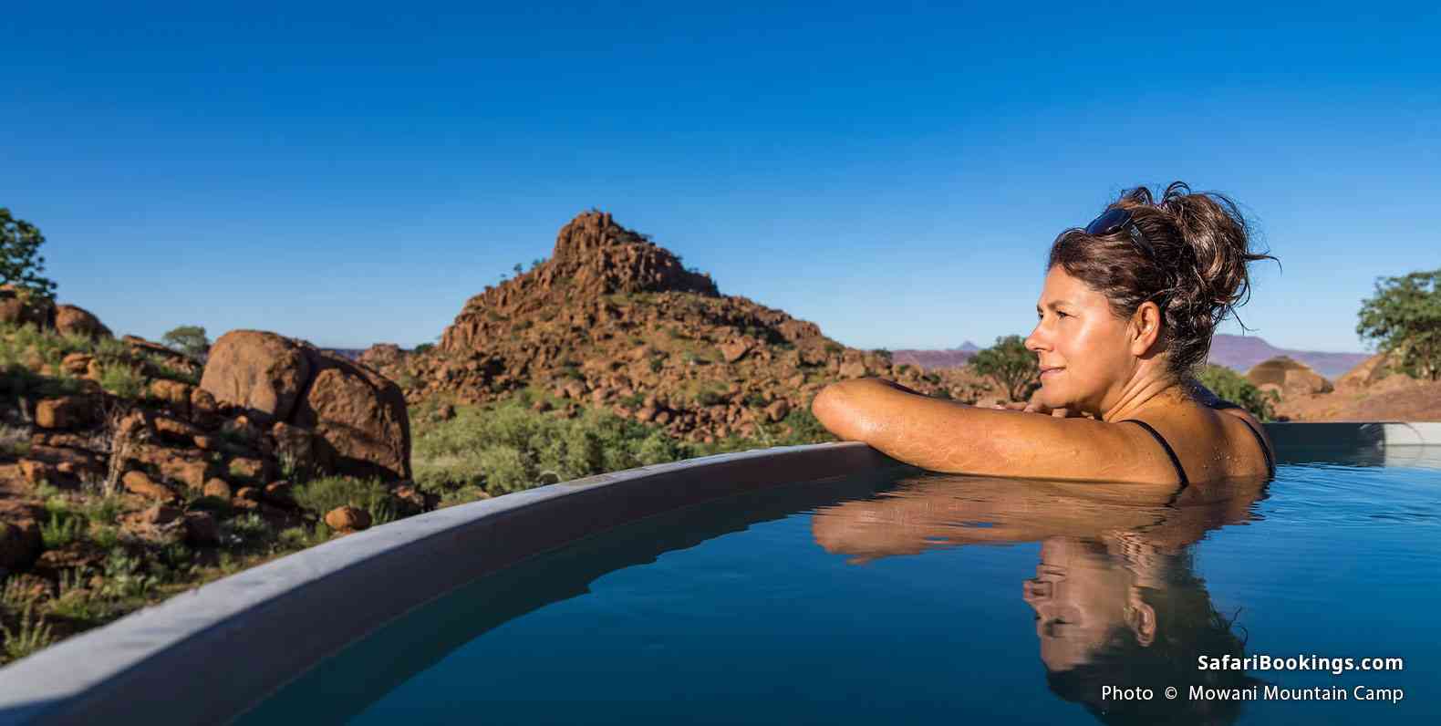 Traveler enjoying pool time with a rocky view at Mowani Mountain Camp