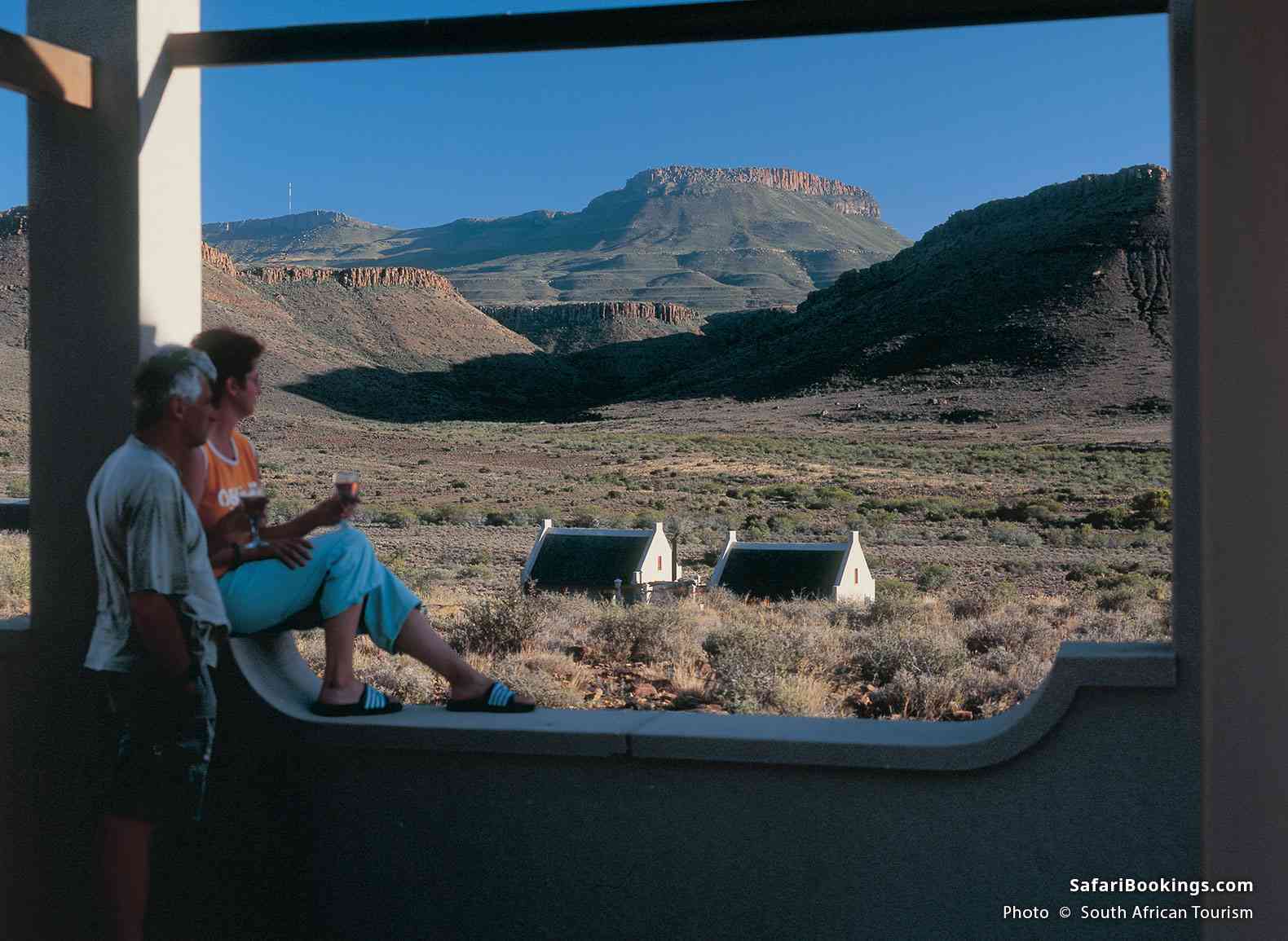 Travelers enjoying a glass of wine at dusk while viewing over Central Karoo