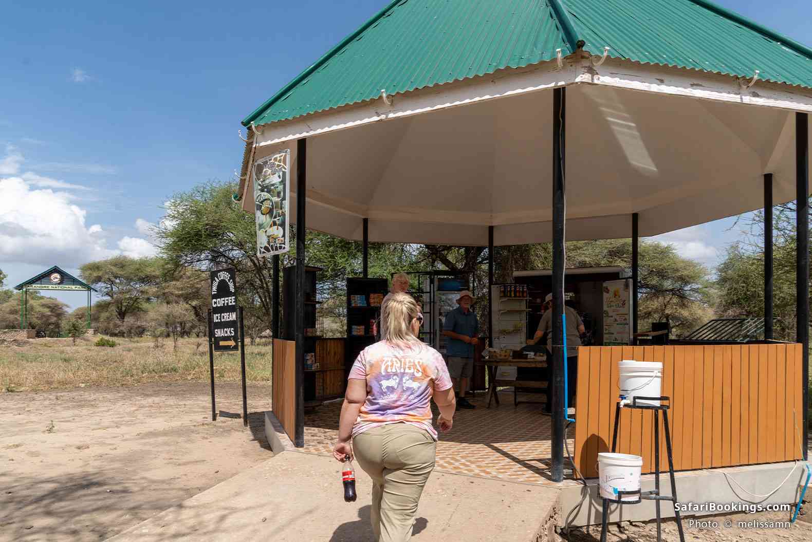 Traveler walks into a small coffee shop hut outside the entrance to Tarangire National Park
