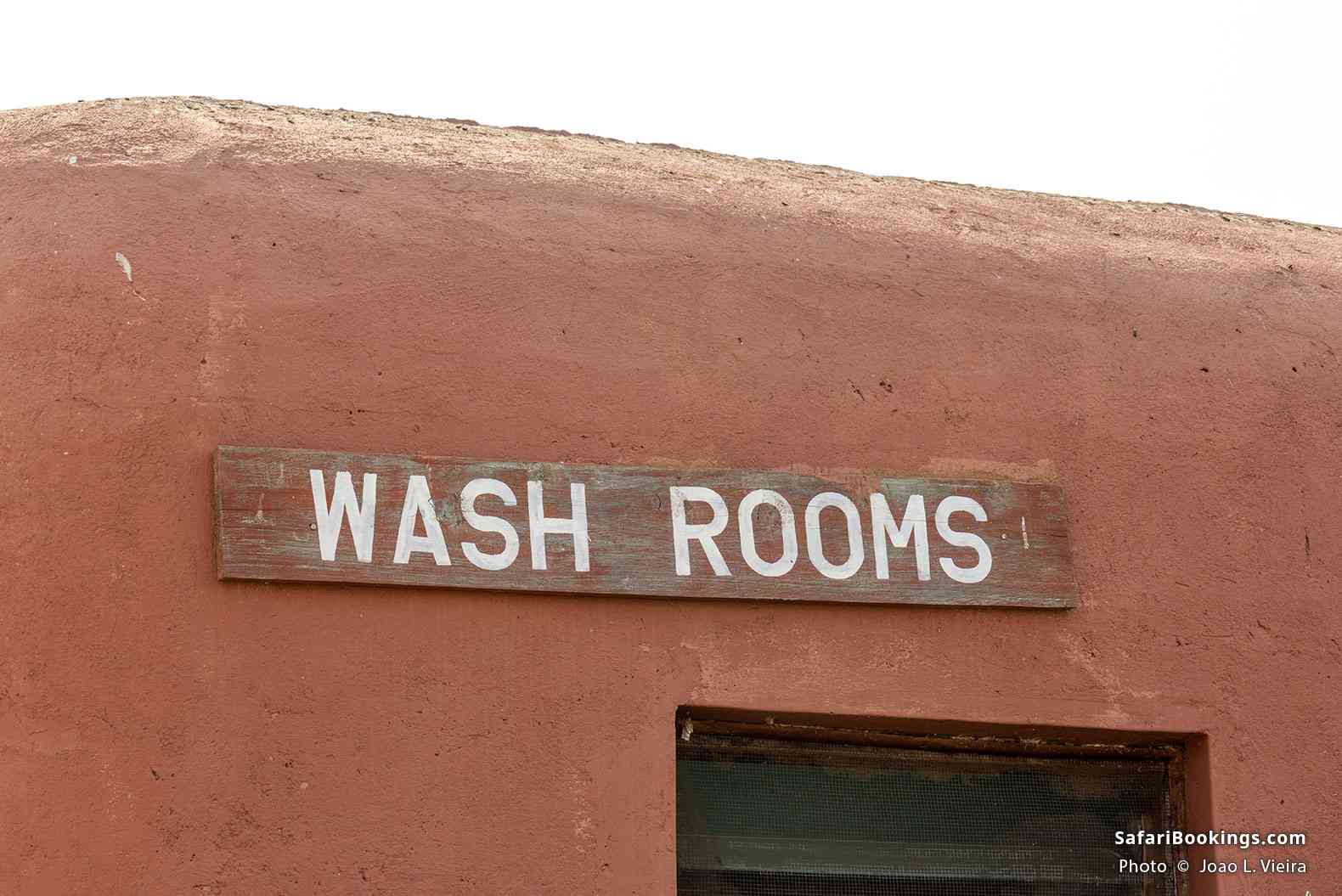 “Wash rooms” sign on a traditional mud building in Amboseli