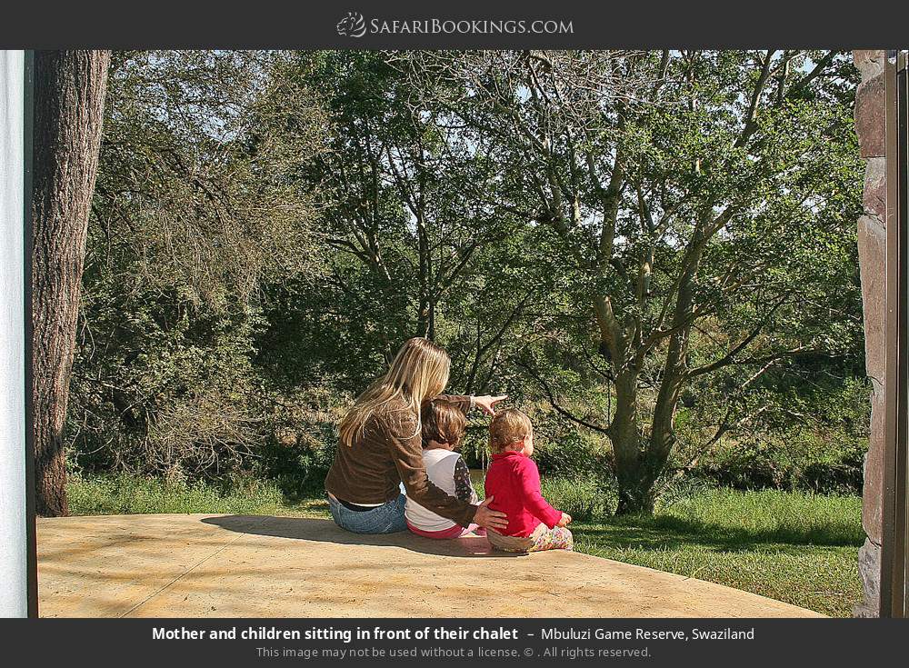 Mother and children sitting in front of their chalet in Mbuluzi Game Reserve, Eswatini