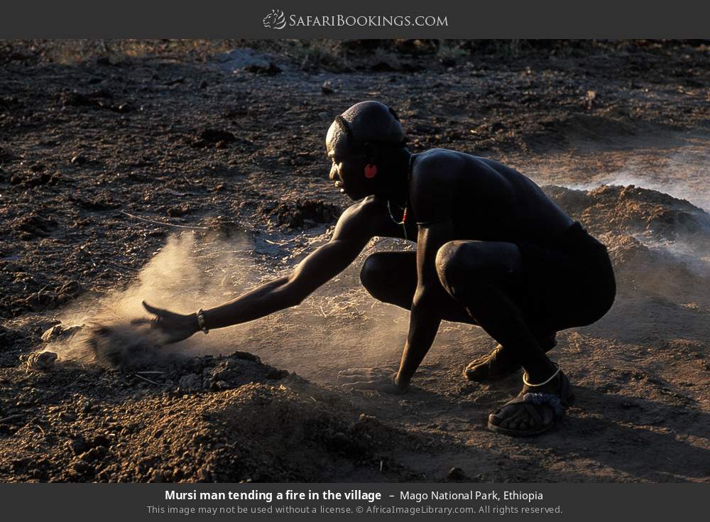 Mursi man tending a fire in the village in Mago National Park, Ethiopia