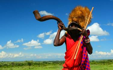 Maasai man blowing a kudu horn