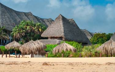 Thatched roofs and sun loungers along beach