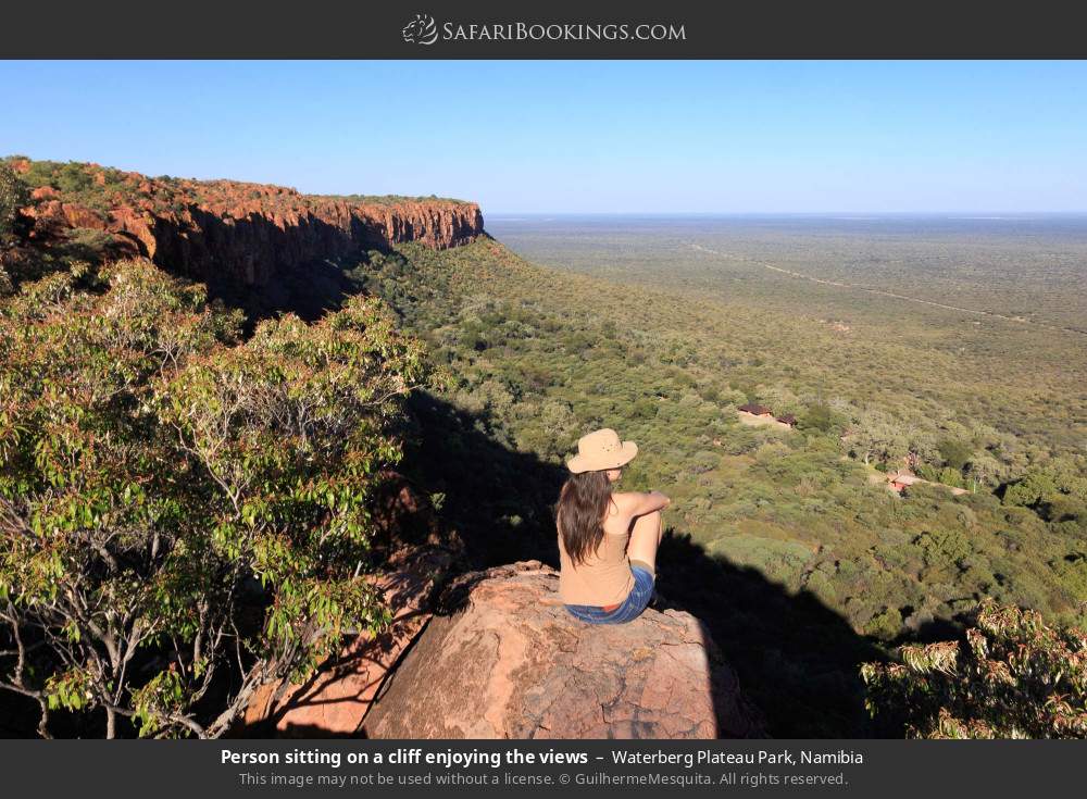 Person sitting on a cliff enjoying the views in Waterberg Plateau Park, Namibia