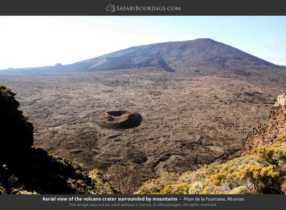 Aerial view of the volcano crater surrounded by mountains in Piton De La Fournaise, Réunion