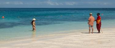 Visitor talking to a Maasai man on the beach