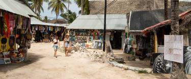 Visitors walking through the market area of Paje village