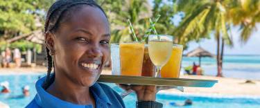Waitress carrying drinks to the beach