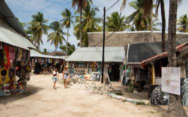 Thumbnail of Visitors walking through the market area of Paje village