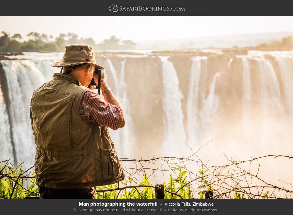 Visitor photographing Victoria Falls in Victoria Falls, Zimbabwe